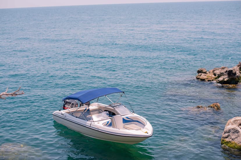 Wooden fishing boats docked by the shore of Lake Malawi with mountains in background
